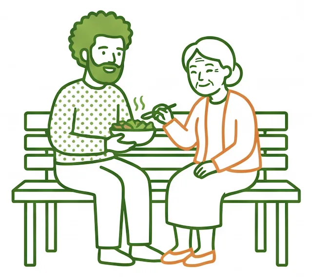 Support worker and older woman sharing a warm meal together on a park bench